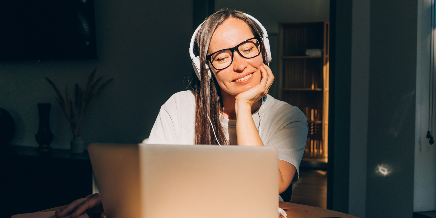 Woman smiling while working on a laptop at a desk
