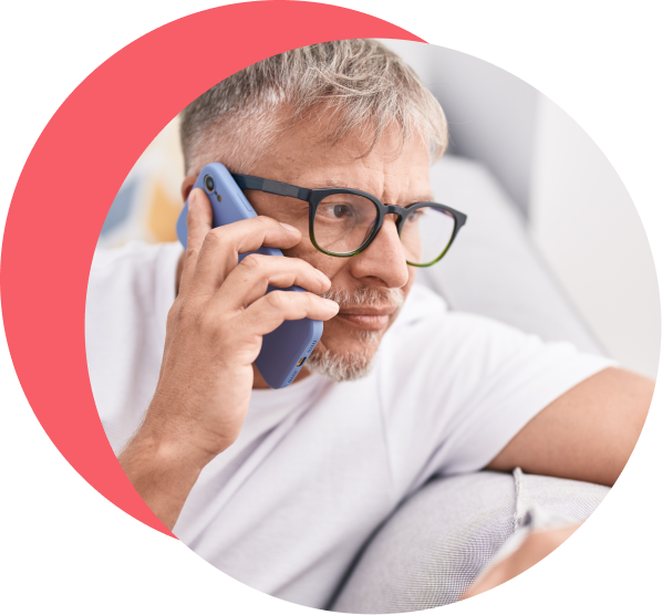 ●	Man consulting with an online doctor over the phone from his sofa