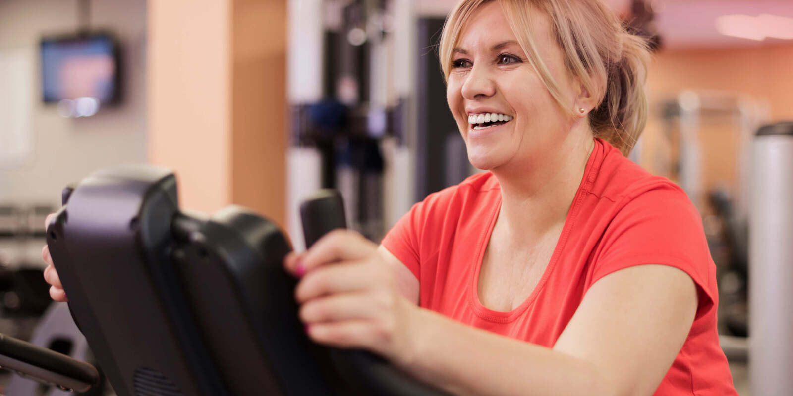 A woman happily working out on a treadmill