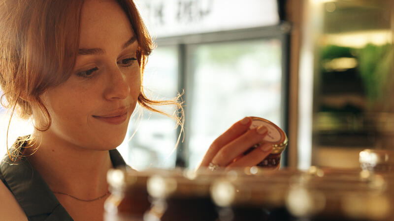 Woman smiling and looking at a sauce bottle
